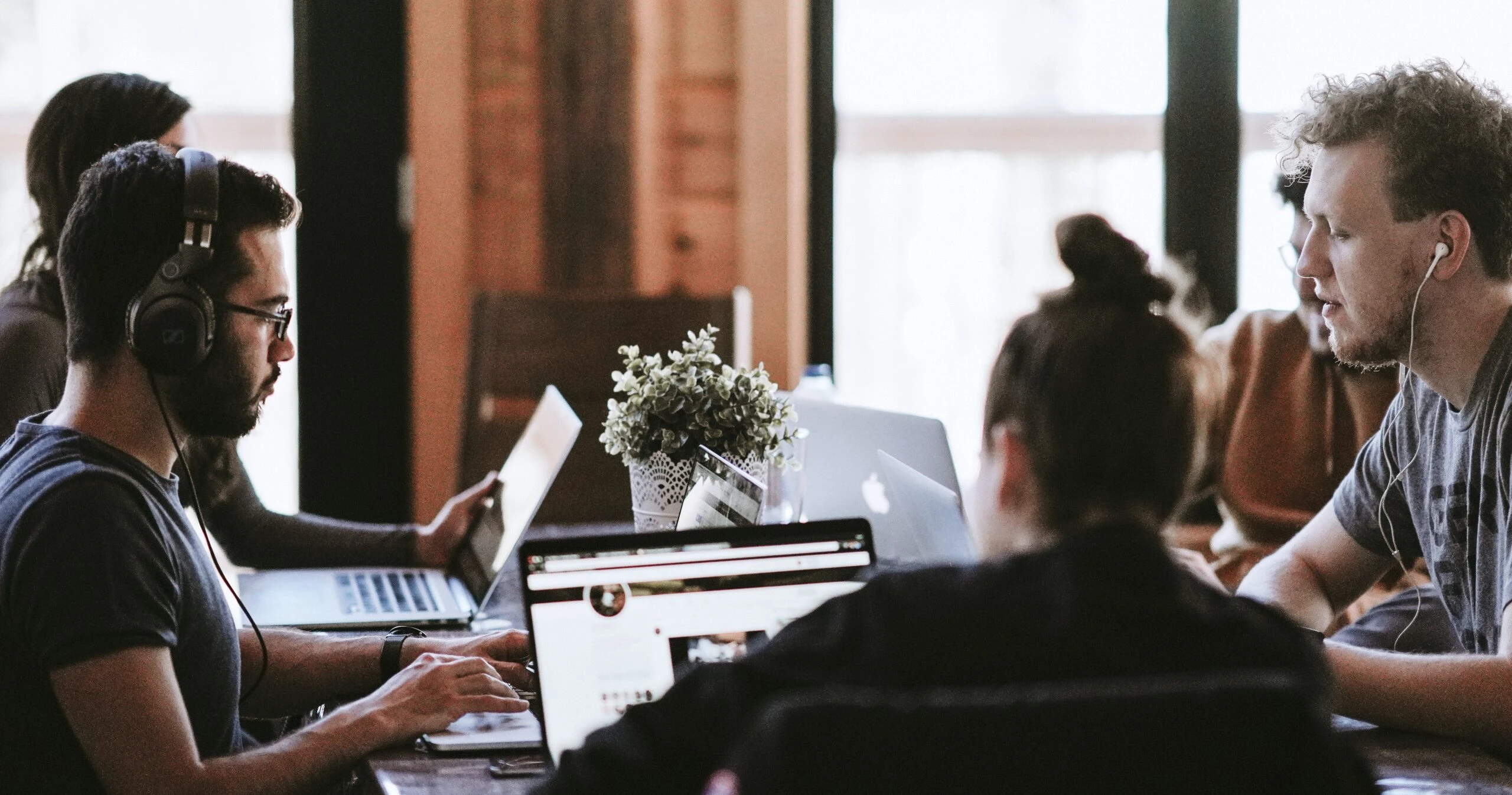 Equipo de diseñadores UX reunido con laptops.